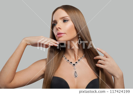 Nice jewellery model woman wearing stylish gold earring and necklace with blue crystal sapphire  117424199