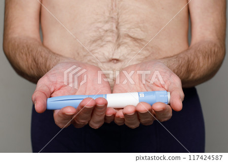 Male hand with Diabetes Insulin Semaglutide Injection pen closeup. 117424587