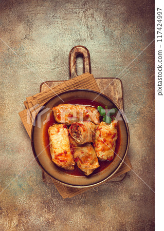 Stuffed cabbage rolls with minced meat, in tomato sauce, top view, without people, in the spotlight. Stuffed cabbage rolls with minced meat, in tomato sauce, top view, without people, in the spotlight. 117424997