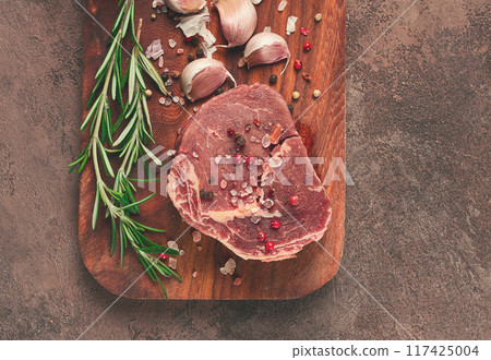 fresh, raw rib eye steak, on a chopping board, top view, no people, 117425004