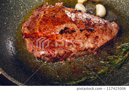 fried steak, beef steak, rib eye steak, in a frying pan, top view, no people fried steak, beef steak, rib eye steak, in a frying pan, top view, no people 117425006
