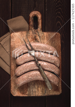 raw sausages in English with bacon, for grilling, on a cutting board, top view, no people, raw sausages in English with bacon, for grilling, on a cutting board, top view, no people, 117425385