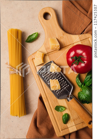 Raw pasta with ingredients, on a beige background, top view, rustic style, selective focus, no people. 117425387