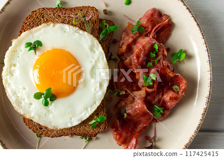 Breakfast, fried egg with bacon, micro-green, on a light background, no people, selective focus, Breakfast, fried egg with bacon, micro-green, on a light background, no people, selective focus, 117425415