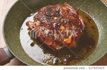 fried steak, veal neck on the bone, cooking meat in a frying pan, top view, no people, fried steak, veal neck on the bone, cooking meat in a frying pan, top view, no people, 117425423
