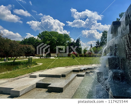 Fountain in the park on a background of blue sky with clouds. Japanese garden at Silesian park, Chorzow, Poland Fountain in the park on a background of blue sky with clouds. Japanese garden at Silesian park, Chorzow, Poland 117425544