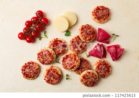 Mini pizzas, salami with mozzarella cheese, on a white table, top view, no people, Mini pizzas, salami with mozzarella cheese, on a white table, top view, no people, 117425615