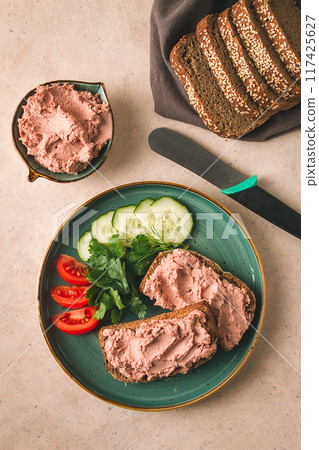 Liver meat pate spread on rye bread, breakfast, close-up, beige background. no people, selective focus, 117425627