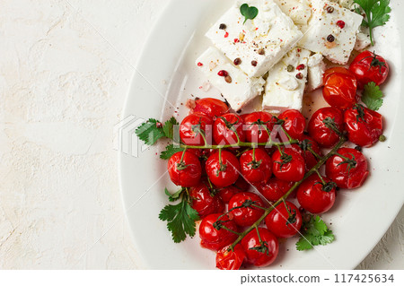 baked cherry tomatoes , with cheese, and spices, on a white plate, homemade, no people, 117425634