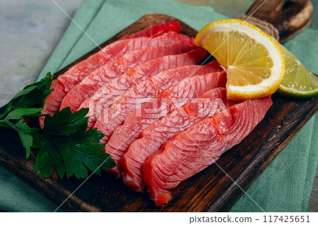 chum salmon, cold smoked, sliced, on a cutting board, with lemon and parsley, top view, close-up, no people, chum salmon, cold smoked, sliced, on a cutting board, with lemon and parsley, top view, close-up, no people, 117425651