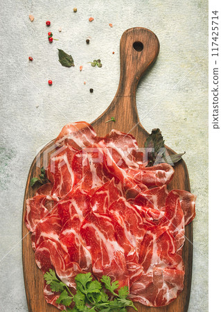 Prosciutto on a cutting board, top view, appetizer, breakfast, spices and herbs, Prosciutto on a cutting board, top view, appetizer, breakfast, spices and herbs, 117425714