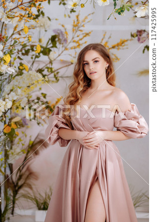 A beautiful woman in a full-length lush pink dress. A beautiful woman in a full-length lush pink dress. 117425995