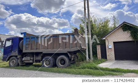 A truck brought sand for the construction site. Bulk cargo delivery. unloading process 117426402