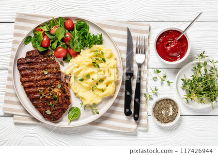 grilled pork steak with mashed potato and salad 117426944