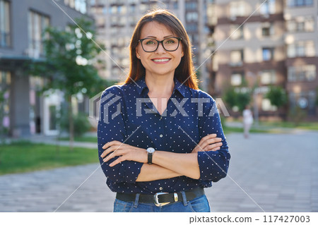 Portrait of middle-aged confident woman posing outdoors 117427003
