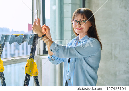 Female decorator of final finishing, repair manager in new apartment office Female decorator of final finishing, repair manager in new apartment office 117427104