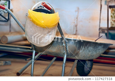Plastic protective mask on construction metal wheelbarrow Plastic protective mask on construction metal wheelbarrow 117427318
