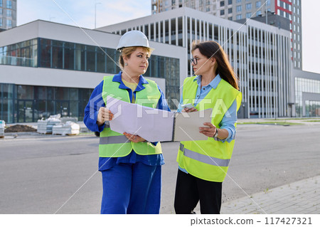 Two confident women talking working on construction of residential office building Two confident women talking working on construction of residential office building 117427321