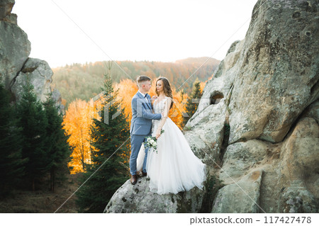 Loving husband and woman on the background of the mountains. Loving couple emotionally spends time Loving husband and woman on the background of the mountains. Loving couple emotionally spends time 117427478