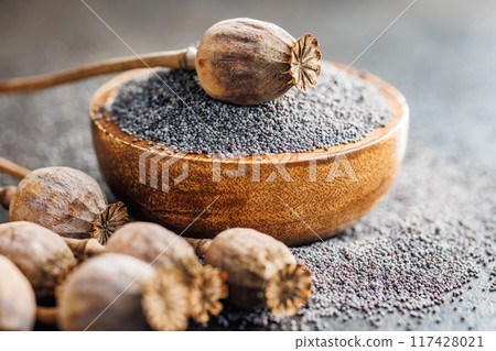 Dry head and poppy seed in bowl on kitchen table. 117428021