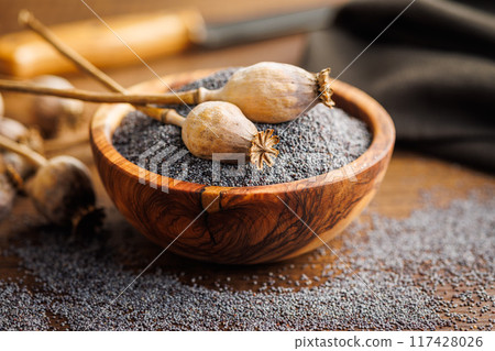 Dry head and poppy seed in bowl on kitchen table. Dry head and poppy seed in bowl on kitchen table. 117428026