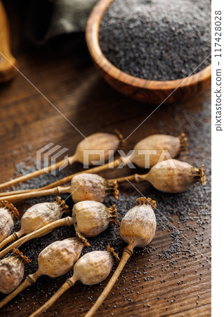 Dry poppy seed and poppy head on wooden table. 117428028