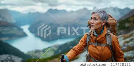 Elderly woman hiking on a mountain trail. Middle-aged woman hiking 117428131