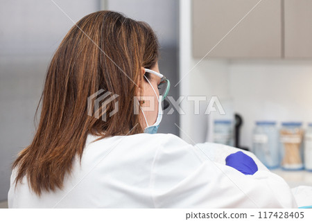 Dermatologist carrying out a skin biopsy on the face of a senior adult patient 117428405