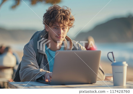 Caucasian man in casual clothes using laptop Working at a desk on the beach. Caucasian man in casual clothes using laptop Working at a desk on the beach. 117428760