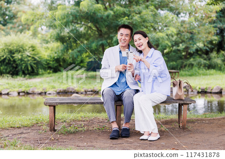 Senior couple taking a selfie with a smartphone Senior couple taking a selfie with a smartphone 117431878