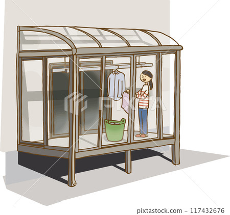 Woman hanging out laundry in sunroom 117432676
