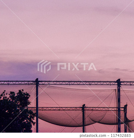 Golf driving range net and evening sky 117432883