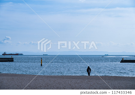 A young man staring at the sea 117433346
