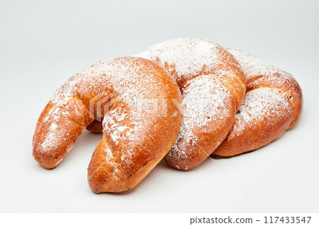 Fluffy crescent rolls filled with jam and dusted with powdered sugar, perfect for a sweet treat Fluffy crescent rolls filled with jam and dusted with powdered sugar, perfect for a sweet treat 117433547