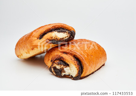Freshly baked poppy seed rolls, golden brown with a rich filling, perfect for a sweet treat 117433553