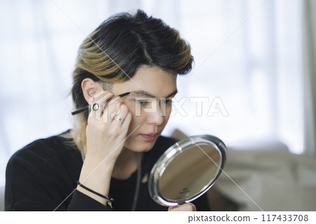 A man in his 20s putting on makeup 117433708
