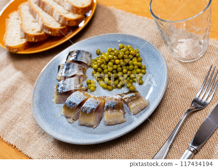Sliced mackerel fish served with peas 117434194