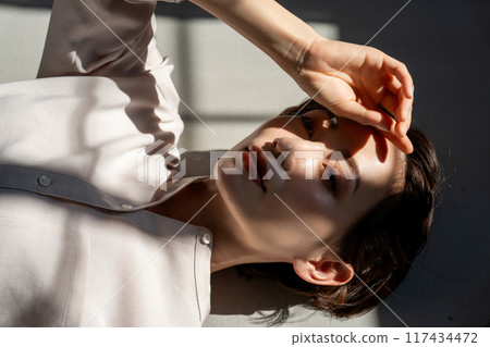 Middle-aged woman lying on floor Middle-aged woman lying on floor 117434472