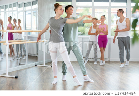 Boy and girl in pair train to perform ballet dance during rehearsal in studio Boy and girl in pair train to perform ballet dance during rehearsal in studio 117434484