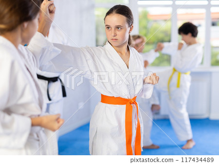 Young pupils train to perform defensive karate installations and attacking combat techniques 117434489