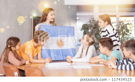 Teacher showing Argentina flag to group of schoolchildren 117434523