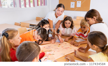Teacher and pupils playing board game in school 117434584