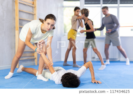 Preteen children pairs learning strength self-defense in gym 117434625