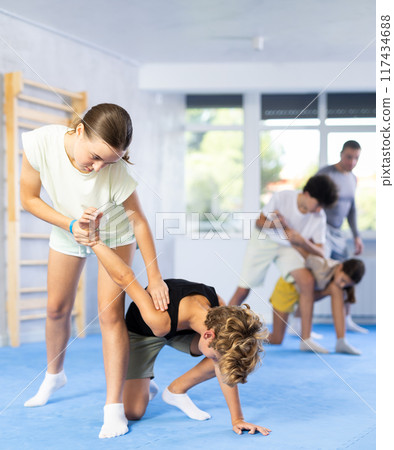 Girls and boys adolescents of performing protection with wring hands during training in self-defense Girls and boys adolescents of performing protection with wring hands during training in self-defense 117434688