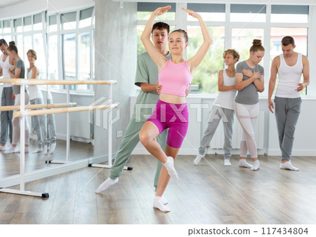 Boy and girl in pair train to perform ballet dance during rehearsal in studio Boy and girl in pair train to perform ballet dance during rehearsal in studio 117434804