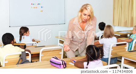 Woman teacher helping pupil explaining new theme 117434806