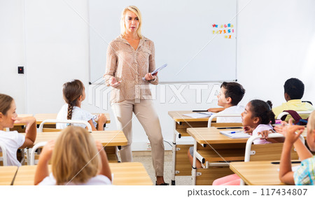 Woman teacher lecturing to pupils at classroom 117434807
