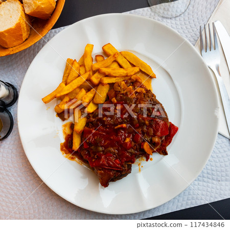 Roasted pork cheek with vegetable salsa and fries 117434846