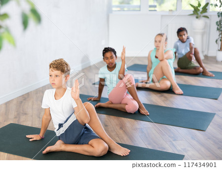 Little children practicing yoga indoors. 117434901