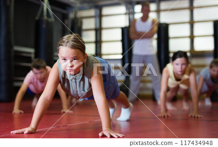 Preteen girl doing push-up during training 117434948